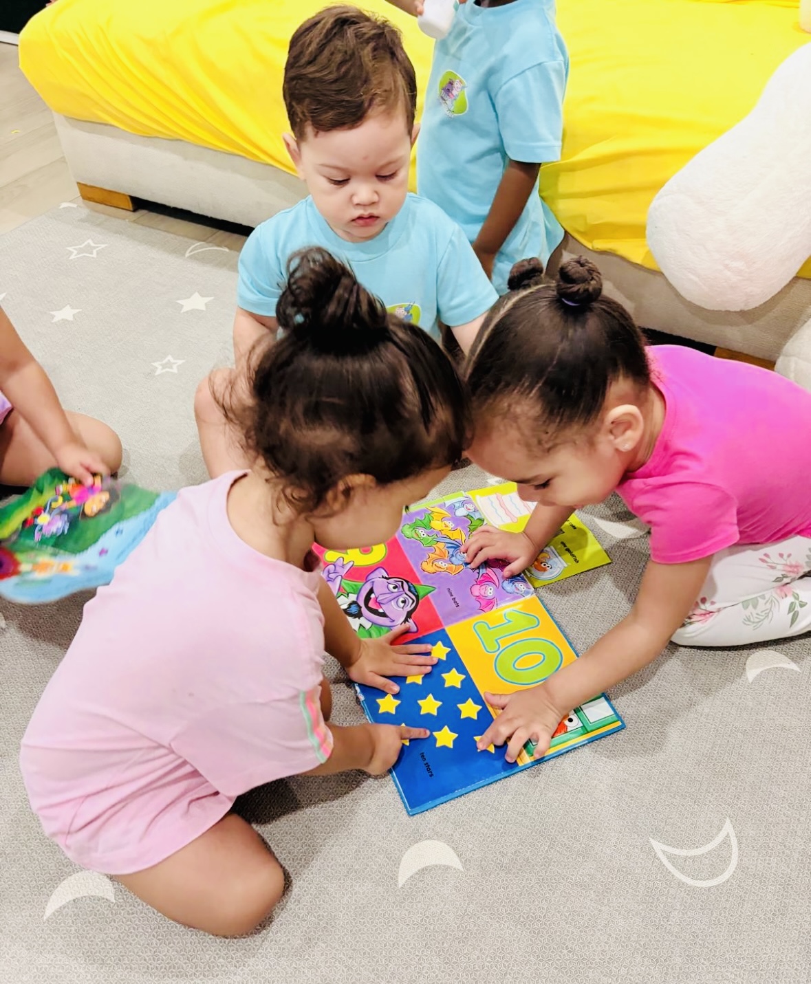 Young children learning together with a colorful book